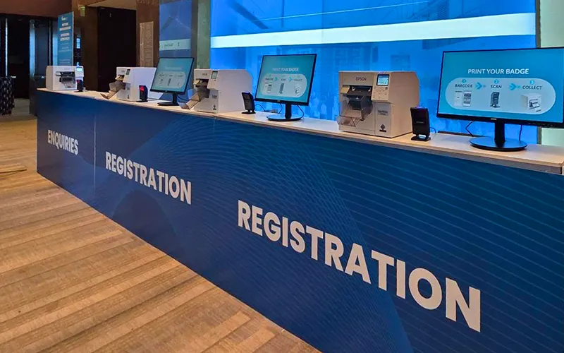 People using Registration Desks at entrance to event