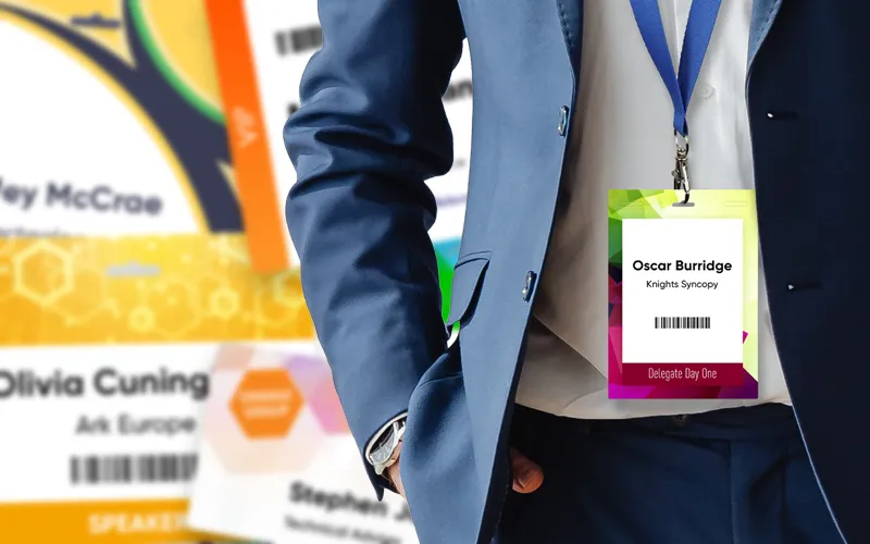Man wearing an event badge with blurred badges as a background