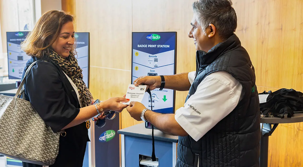RefTech staff handing a badge to attendee