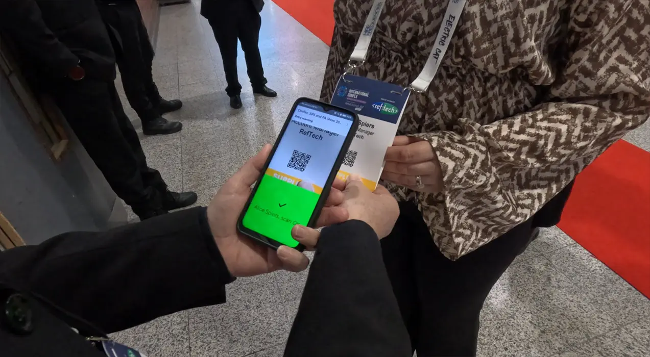 Woman having her badge scanned, using ScanPod Mobile on a smartphone, at the entrance to a meeting room