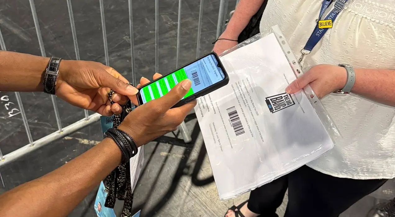 Person having their printed barcode scanned, using ScanPod Mobile on a smartphone, to gain entrance to an event