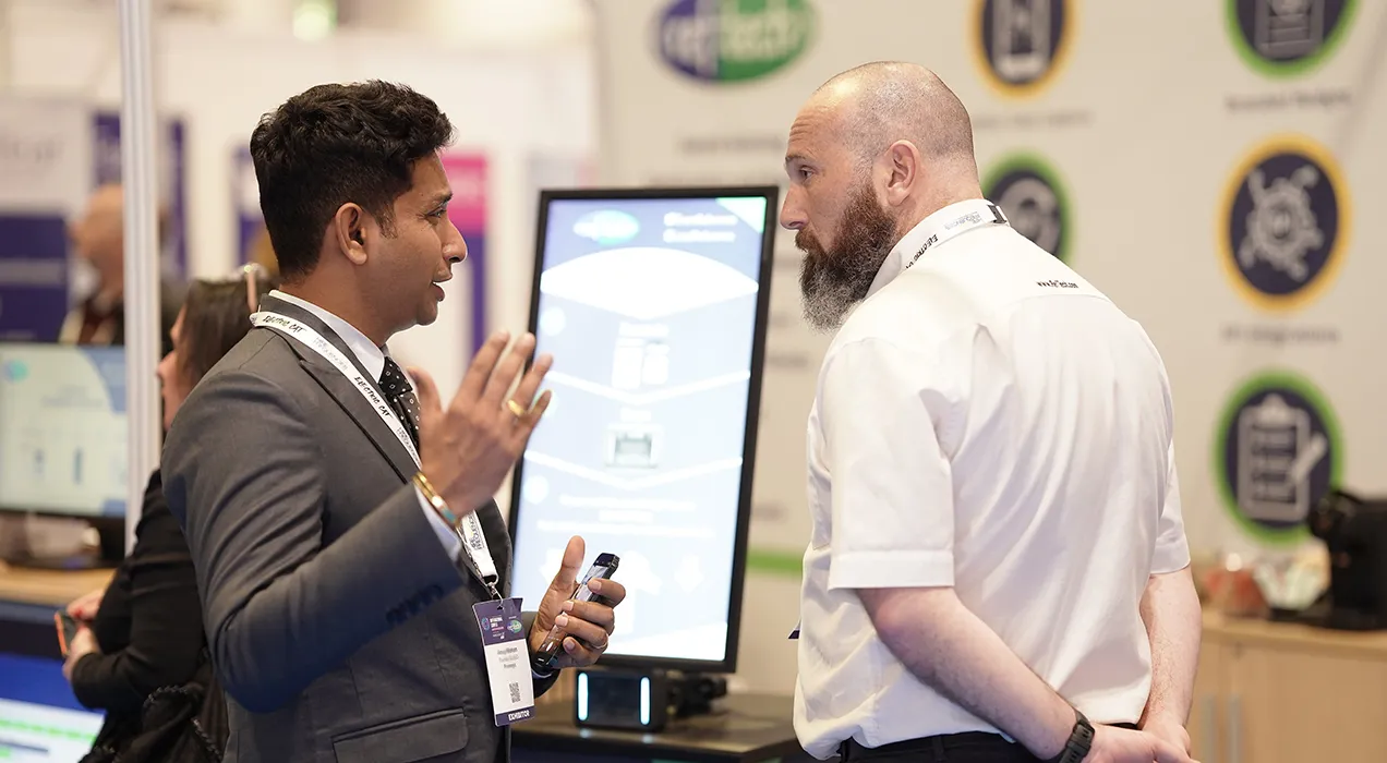 RefTech team member on exhibition stand talking to interested person